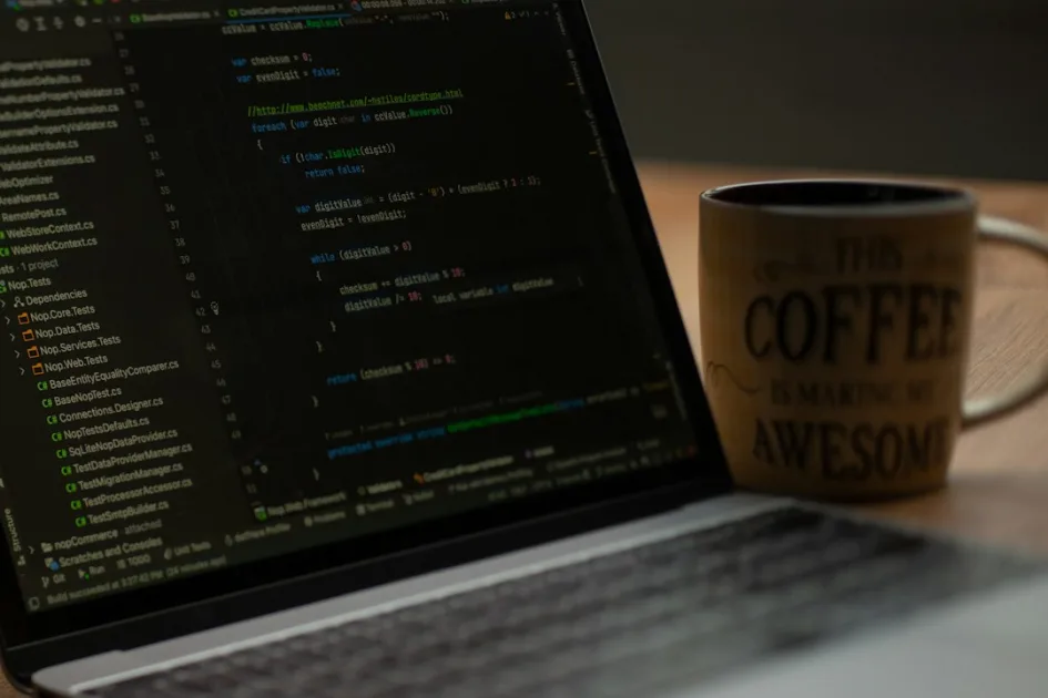 Laptop screen displaying code next to coffee mug